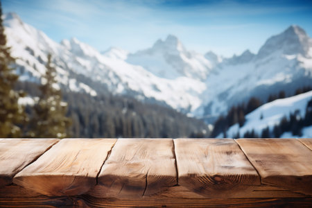 Wooden table against snow covered mountain tops in the background. Collage.の素材