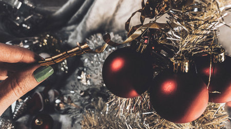 Closeup of woman hands decorating christmas tree with baublesの写真素材