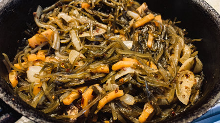 Seaweed salad with onions and carrots in a cast iron skilletの写真素材