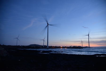 Eletric Power Generator Wind Turbine over a Cloudy Sky in Jeju Coastの写真素材
