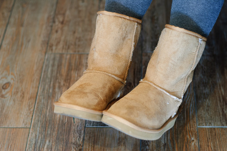 Closeup of brown Ugg boots with wooden backgroundの写真素材