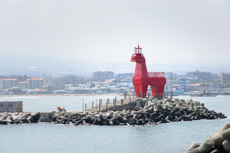 horse shaped lighthouse on a breakwater with tetrapod near the Iho Teu beach in Jeju Island, Korea.の写真素材