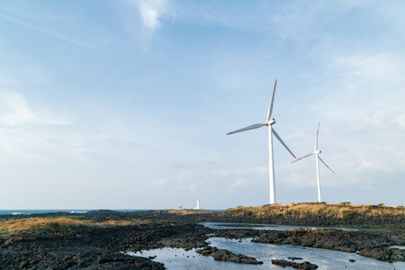 cloudy evening landscape with two windgenerator at a coast in Jeju Island, Korea.の写真素材