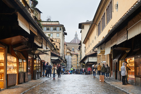 Florence, Italy - Febuary 17, 2016: Street View of Ponte Vecchio, a medieval stone bridge over the Arno River in Florence. It is famous for still having shops built alog the bridge.のeditorial素材