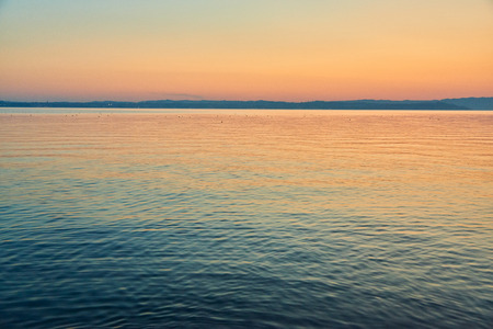Sunset of Lake Garda, View from Sirmione peninsula which divides the lower part of Lake Garda. It is a famous vacation place for a long time in northern Italy.の写真素材