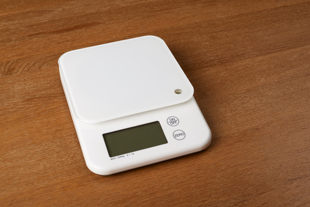 empty white food scales on a wooden tableの写真素材