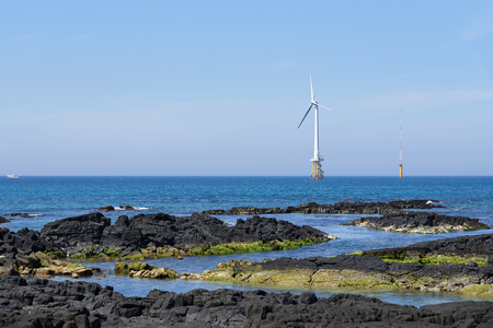 Landscape of coast with wind generator in Gujwa-eup, Jeju, Korea. Jeju Island is famous for its beautiful natureの写真素材