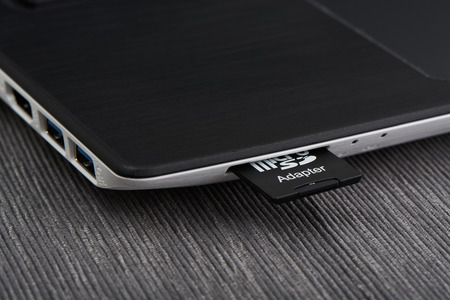 Close up of SD card inserted in laptop card reader slot