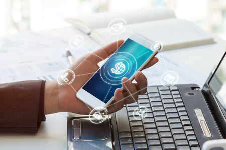 Close up hand business woman/ man holding mobile phone with Mobile banking icon flowの写真素材