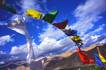 Prayer flags flying below the blue skyの素材