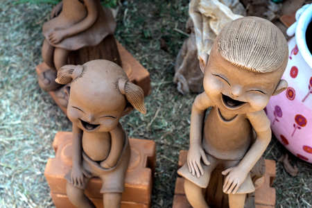 Small unfinished clay sculture decorative objects of happy Asian kidsの写真素材