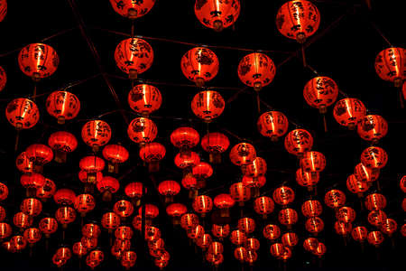 Red bright Chinese lanterns at night with wealth and luck calligraphy decorated for Chinese Lunar New Yearの写真素材