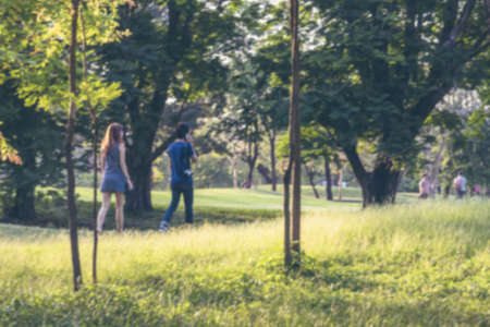 Blurred Asian couple strolling in the park in summer on a weedendの写真素材