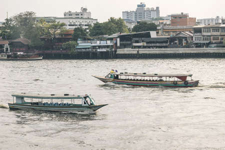 BANGKOK,THAILAND-APRIL 12,2015: Express boats is a popular means of transportation for tourists and local along Chao Phraya River. (Film filtered applied )のeditorial素材