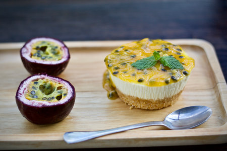 Passion fruit cheesecake on wooden plate,selective focus.の写真素材