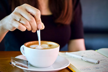 A cup of coffee with latte art on wooden table in coffee shopの写真素材