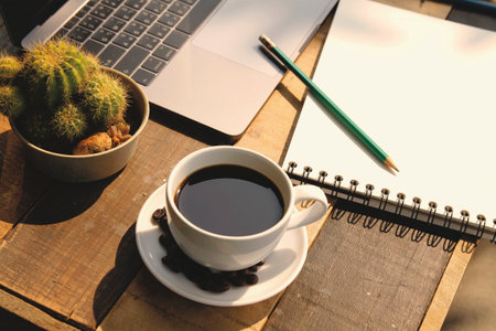Coffee cup with notebook and pencil on wooden table, stock photoの写真素材