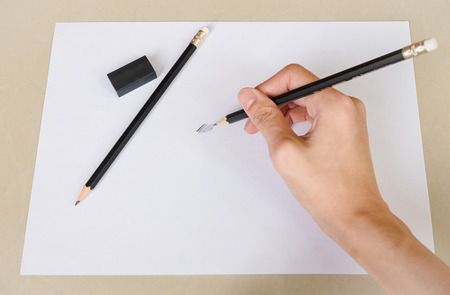 Hand writing something by Pencil Eraser in white paper and Erase rubber on Deskの写真素材