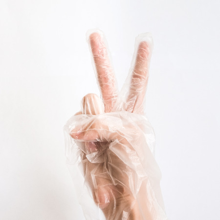 Hand wearing Transparent Disposable Plastic Glove Isolated on white Backgroundの写真素材
