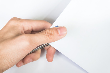 closeup of hand using stapler machine with paper - on white backgroundの写真素材