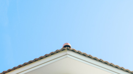 The texture of the red ceramic Tiles on the Roof of a House with Blue Sky backgroundの写真素材