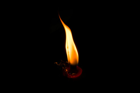 light from burning candle in the darkness for backgroundの写真素材