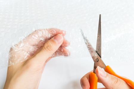 hand cutting Air Bubble Wrap by scissors for Packaging product