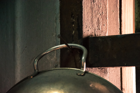 pan hanging on the wall by nail with sunlight shining from the window (old vintage concept)の写真素材