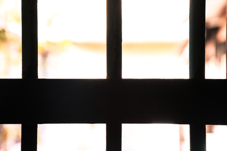 silhouette iron bar installed on window for security concept with sunlight (old vintage style)の写真素材