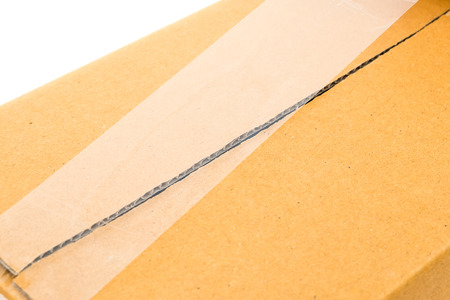 brown cardboard box sealing by transparent packing tape on white backgroundの写真素材