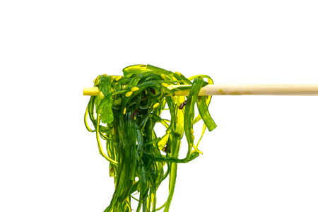 seaweed salad on wooden chopsticks isolated on white backgroundの写真素材