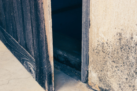 old wooden door open to the dark roomの写真素材