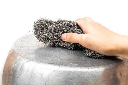 hand scrubbing cooking pot by steel wool on white backgroundの写真素材