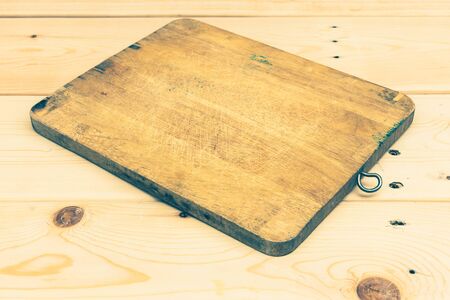 used chopping board on wooden plankの写真素材
