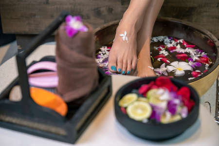 Closeup photo of a female feet at spa salon on pedicure procedure.Spa Wellness Decorations items.Essentials oils and natural products.の写真素材