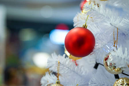CLOSE UP CHRISTMAS ORNAMENT WITH WHITE AND RED STRIBE  COLOR ON THE WHITE CHRISTMAS TREE.の写真素材