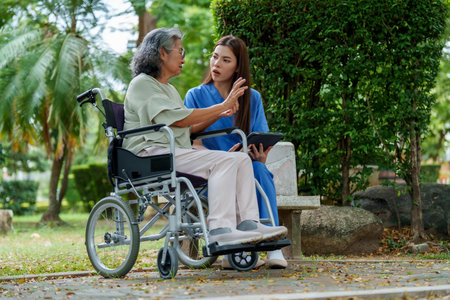 Caring caregiver provides assistance and support to senior in wheelchair, fostering warm connection...