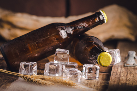 Bottle Draft Beer and ice on wooden table.の写真素材