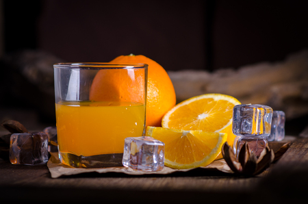 Orange juice and slices on wooden table.の写真素材