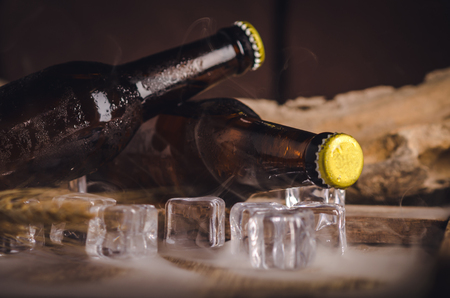 Bottle Draft Beer and ice on wooden table.の写真素材