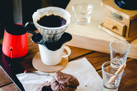 Cookie and Kit coffee drip from steaming filter drip style on the table.の写真素材