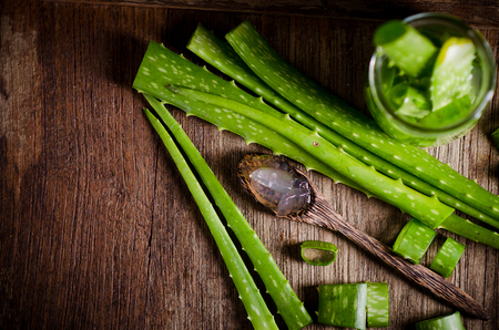 aloe vera gel on wooden spoon with aloe vera on wooden table.の写真素材