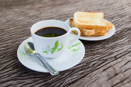Cup of black coffee  with bread on the old wood の写真素材
