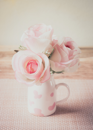 Rose flower of vase on wood table made vintage styleの写真素材