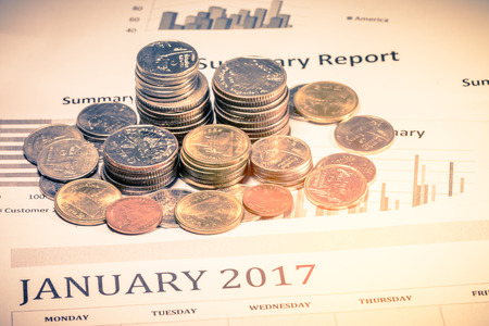 Graphs and charts with stacks of coins on vintage colorの写真素材