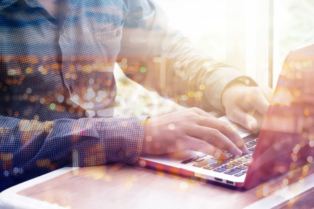 Double exposure businessman typing on the keyboard with blurred bokeh cityscapeの写真素材