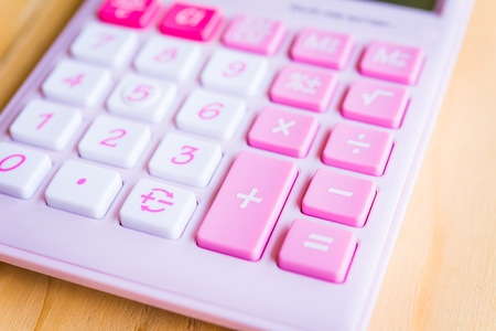 Pink modern calculator on wood table (selective focus)の写真素材