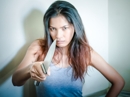 Women with serious anger hand holding a knife(selective focus)の写真素材