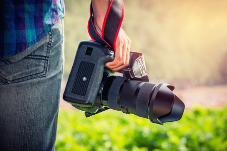 Photographer standing and holding camera in the park
