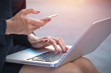 Businesswoman using smartphone and smartphone for business financeの写真素材